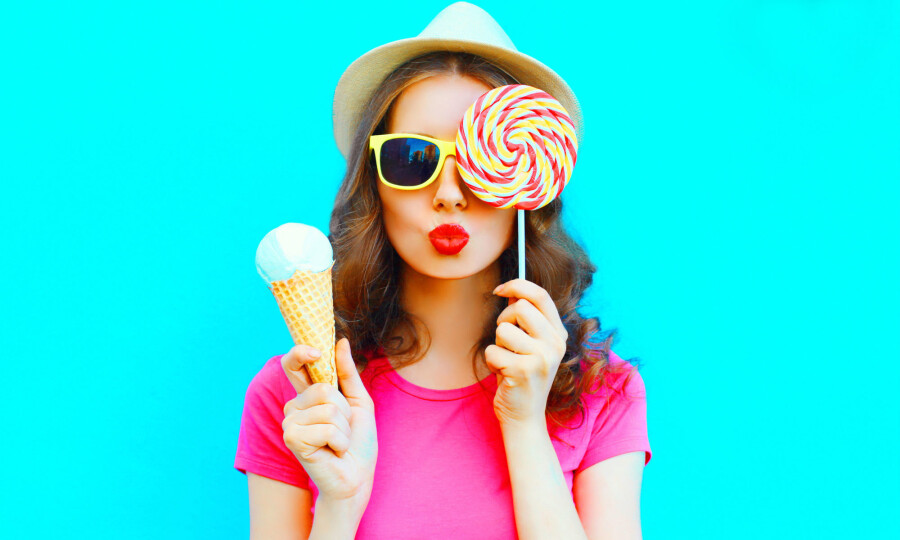 Девушка с мороженым делает воздушный поцелуй