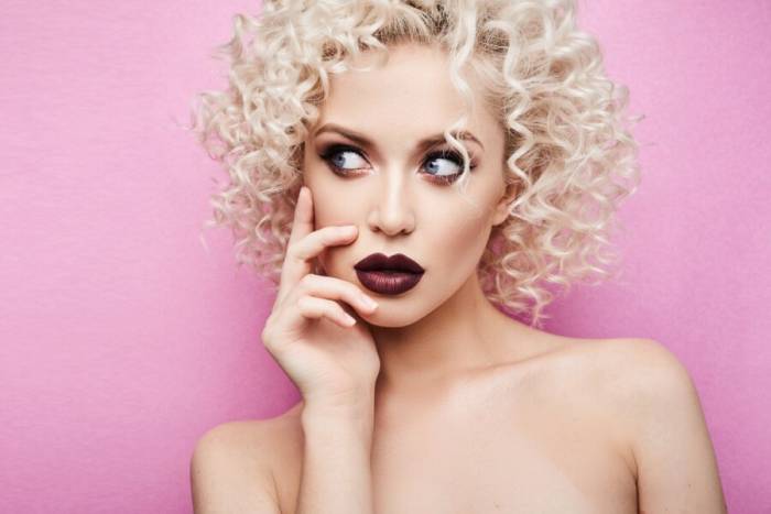 кудрявая девушка на розовом фоне