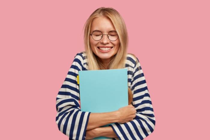 счастливая девушка держит тетрадь