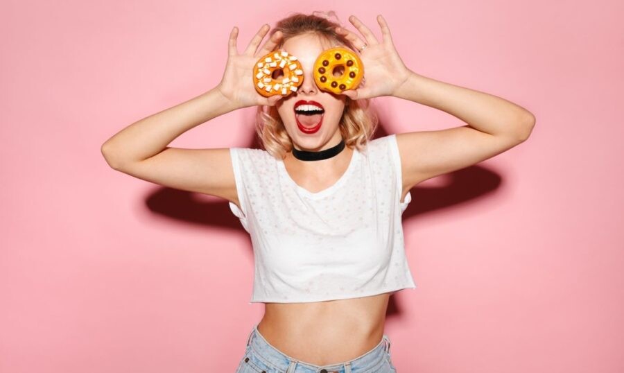 Девушка улыбается с пончиками