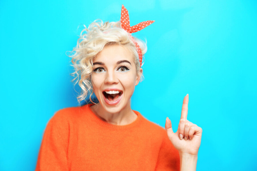 Девушка в оранжевой кофте улыбается